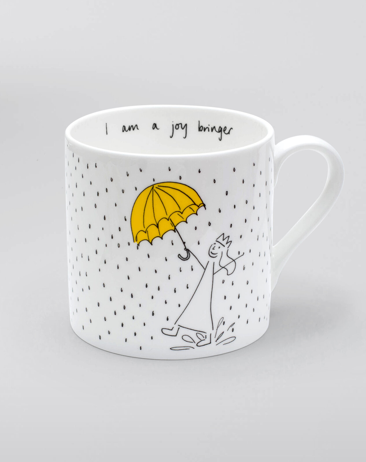 'I Am So Many Things' mug printed with a crowned character under an umbrella, reading 'I am a joy bringer' inside the rim